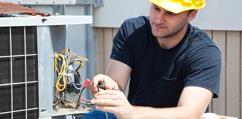 technician repairing air conditioner